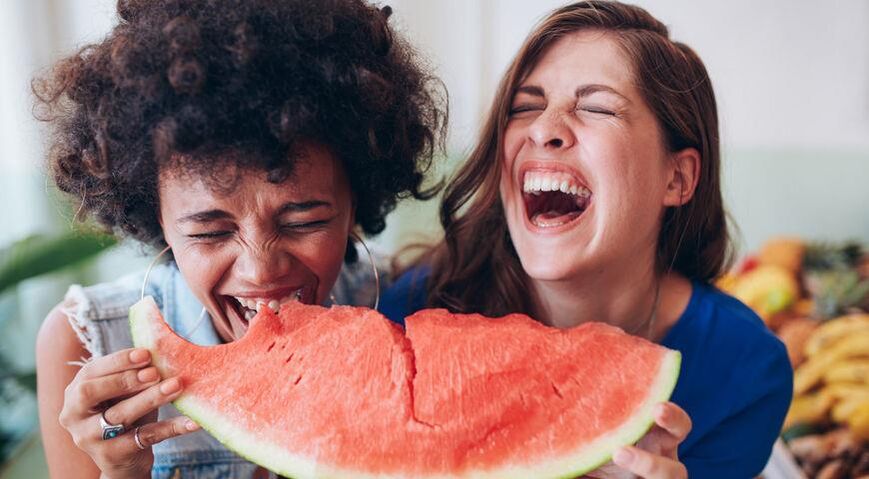 Ang mga batang babaye nagkaon sa watermelon